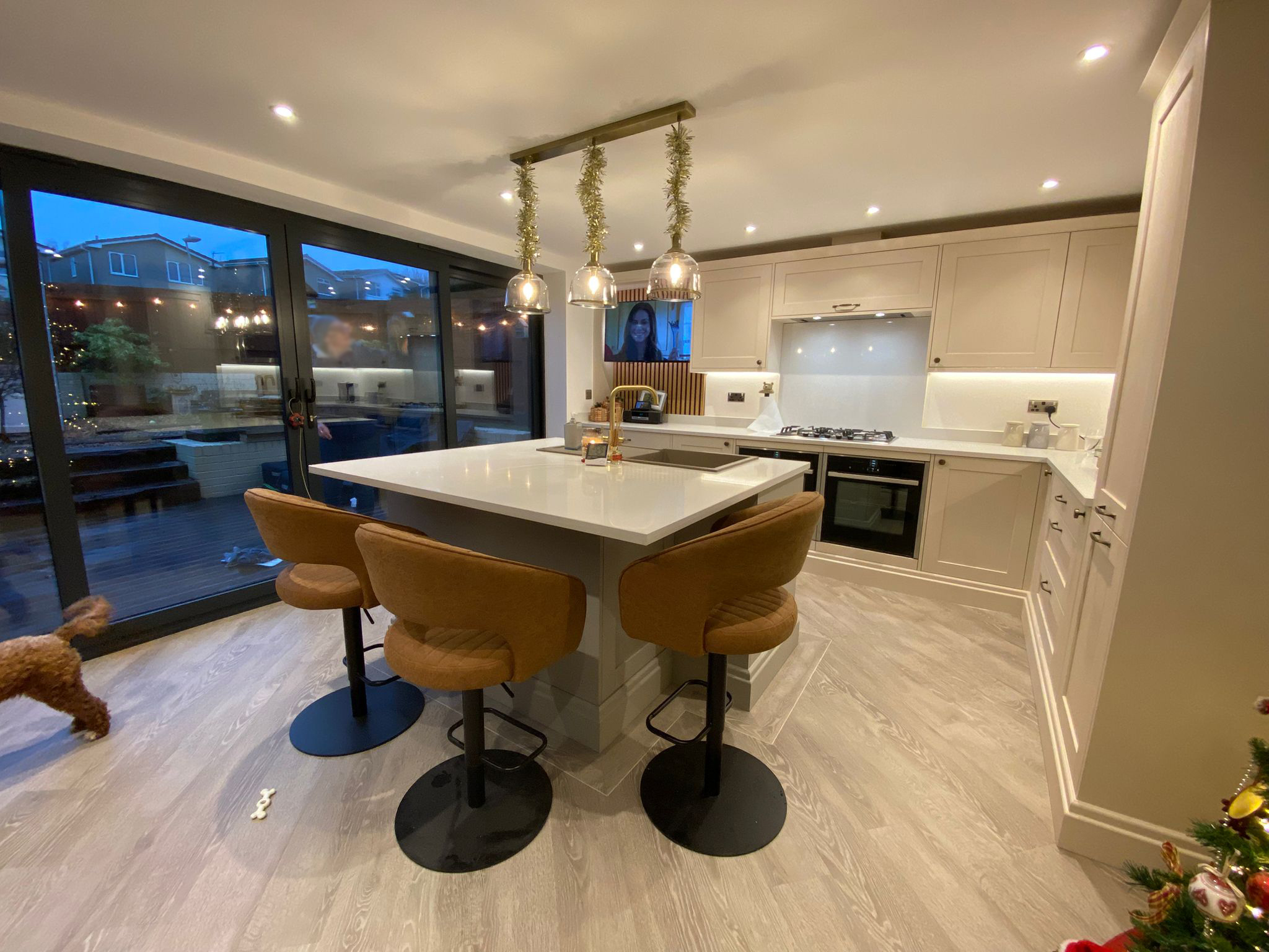 Modern open-plan kitchen with large island, pendant lighting, and seating for three