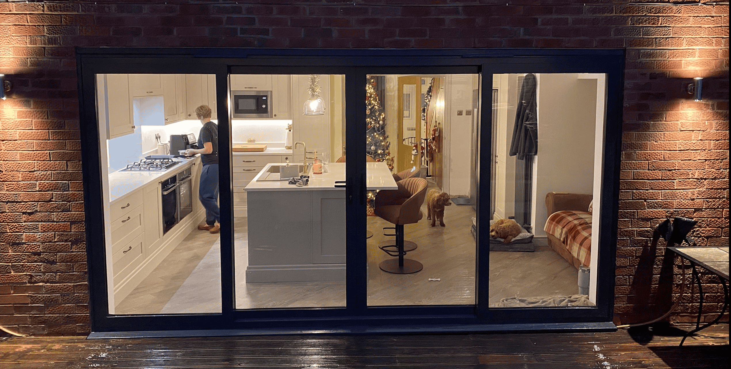 Open-plan kitchen viewed through large sliding doors after renovation