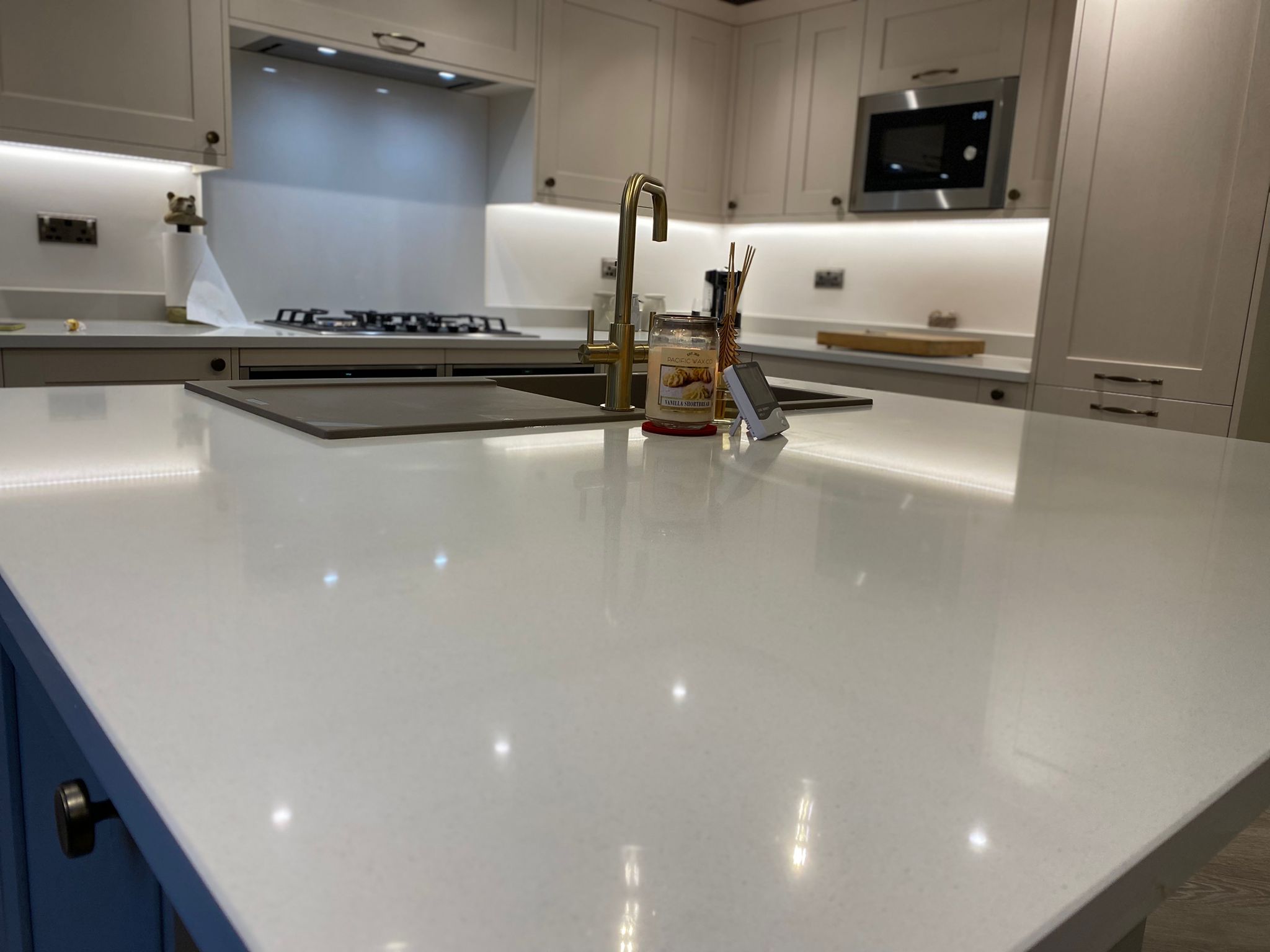 Quartz kitchen island with gold tap and modern appliances