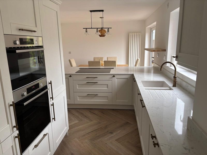 After renovation modern white kitchen with quartz worktops and integrated appliances